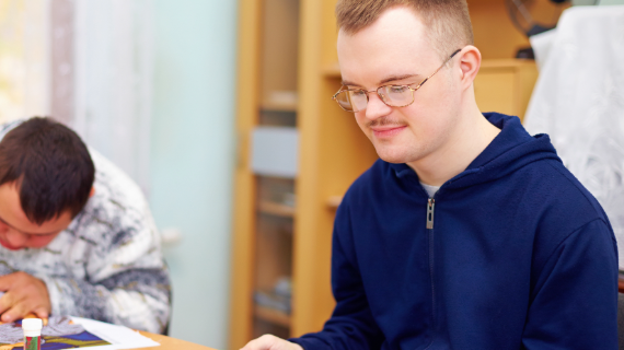 Two males with learning disabilities sitting at a table.