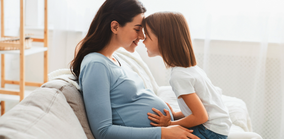 Pregnant woman with child on her knee