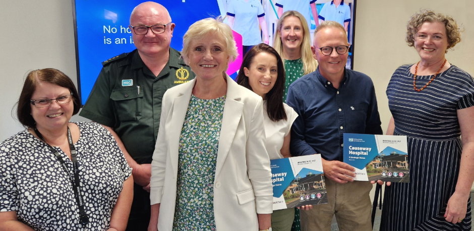 A group of people standing together, some are holding a copy of a the Causeway Vision document