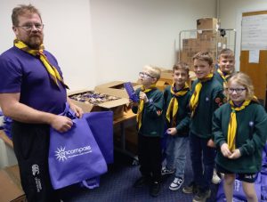 Five scouts and a leader, the leader is holding a purple bag.