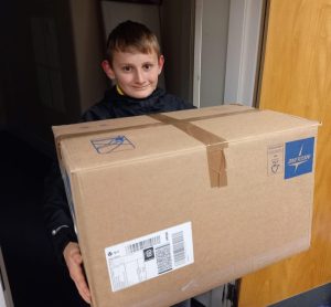 A Scout holding a large cardboard box