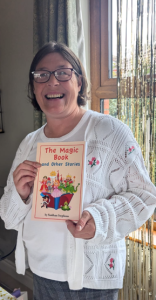 Siobhan Stephens standing, holding a copy of her book.