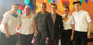 Six people standing together. Four are wearing McDonald's uniforms.
