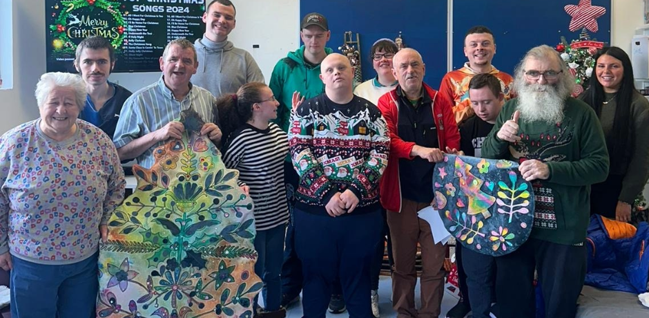 A group of Base service users standing together, some are holding artwork