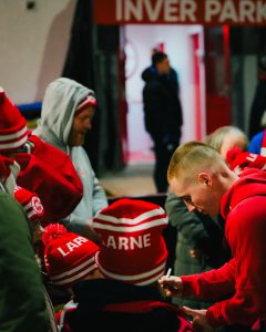 Players sign autographs for young fans.