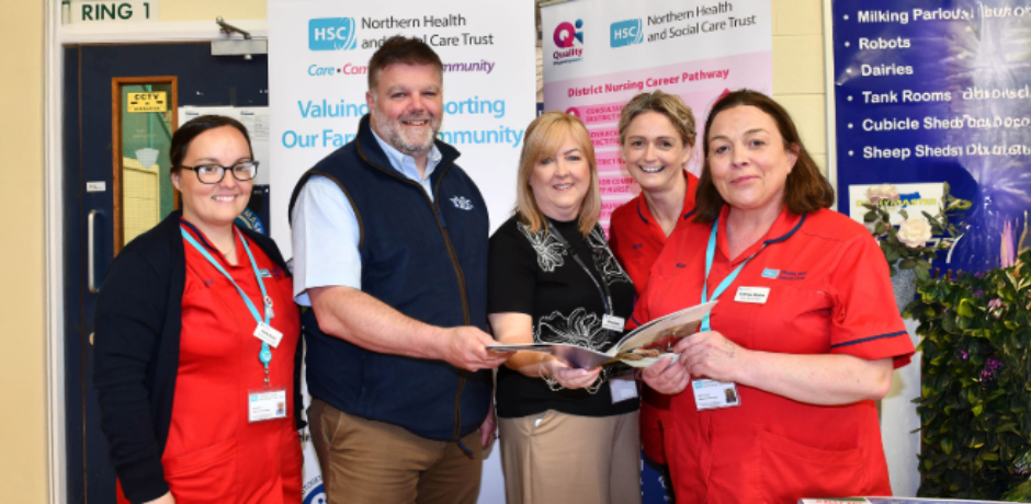 Five staff look at a brochure together