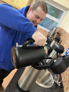 A man pours in to a large flask