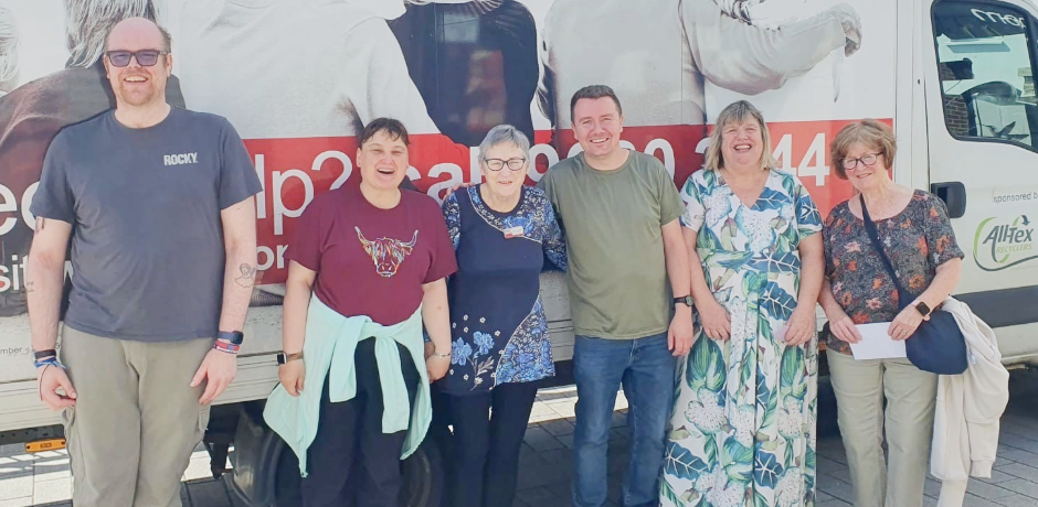 Five people standing in front of an Action Cancer branded van.