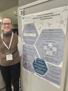 A woman stands in front of a poster display