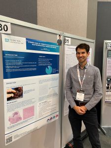 A man stands in front of a poster display.