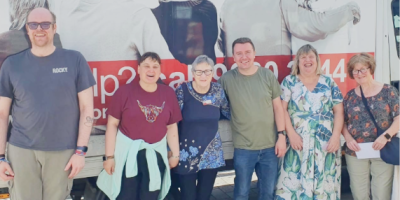 Five people standing in front of an Action Cancer branded van.