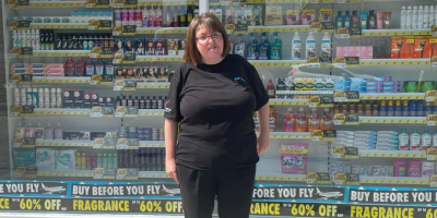 A woman stands outside a Savers shop.