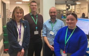 Four people standing together in a hospital setting.