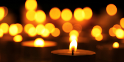 Tea light type candles burning against a dark background