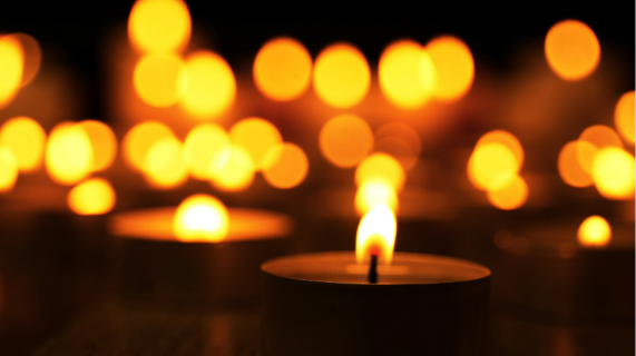 Tea light type candles burning against a dark background