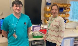 Two people standing together in a clinical setting.