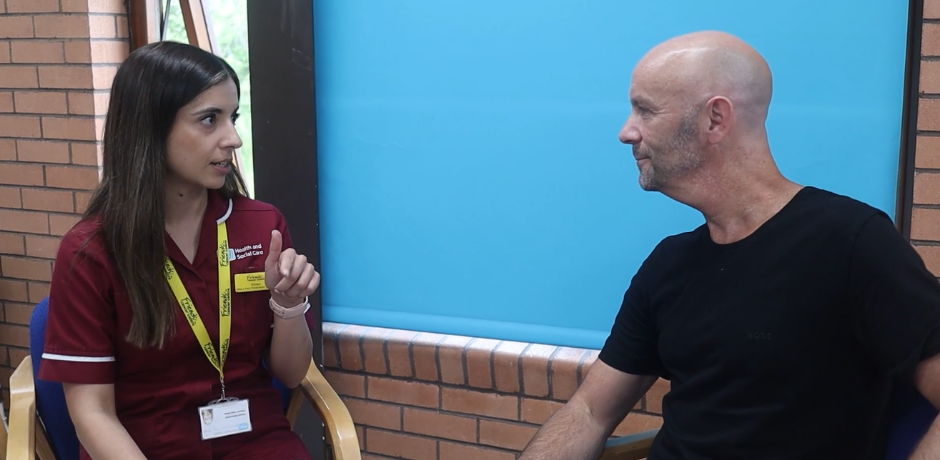 A nurse and patient sitting beside each other while having a conversation.