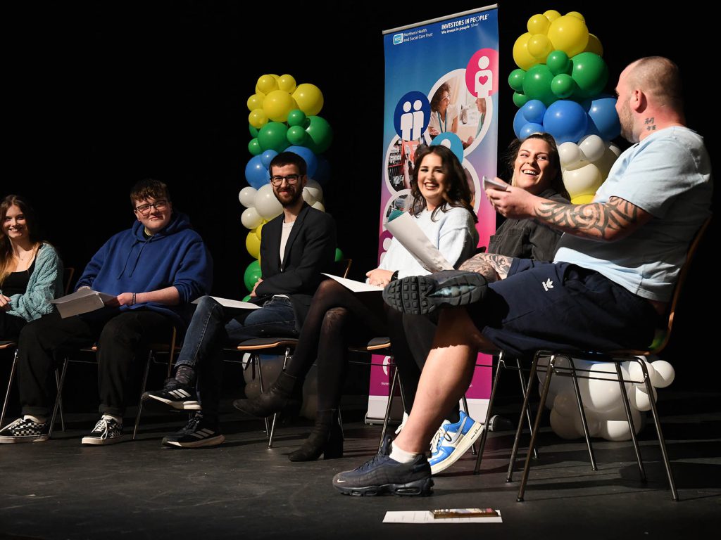 Panel of people sitting in a row holding a discussion