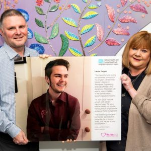 Steve and Linda Hogan holding a storyboard which tells the story of their son Laurie.