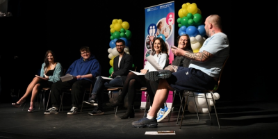 Panel of people sitting in a row holding a discussion.