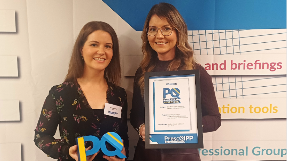 Two women standing together, one is holding a framed certificate.