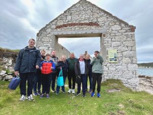 A group of people standing outside an old stone structure on Rathlin Island.