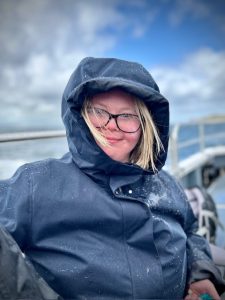 A service user wearing a raincoat, smiling.