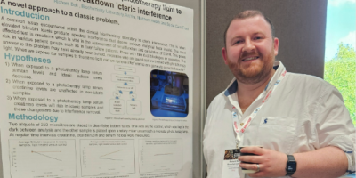 A man stands in front of a poster display.