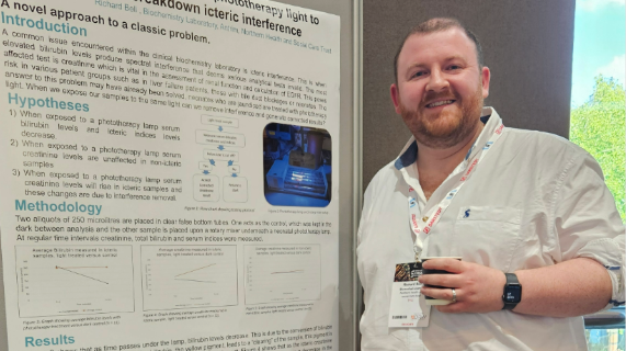 A man stands in front of a poster display.
