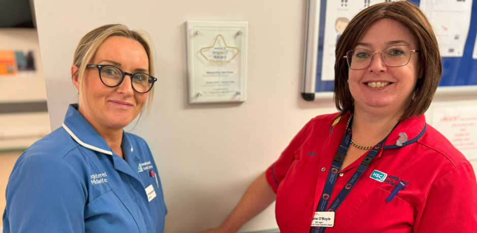 Two healthcare workers, one is wearing a blue tunic and the other a red tunic.