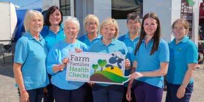 Eight members of the Farm Families Health Checks Team, holding a sign which reads 'Farm Families Health Checks'