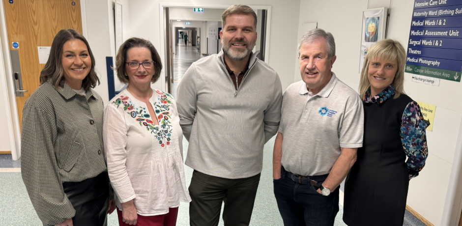 Five people standing together in a hospital corridor.