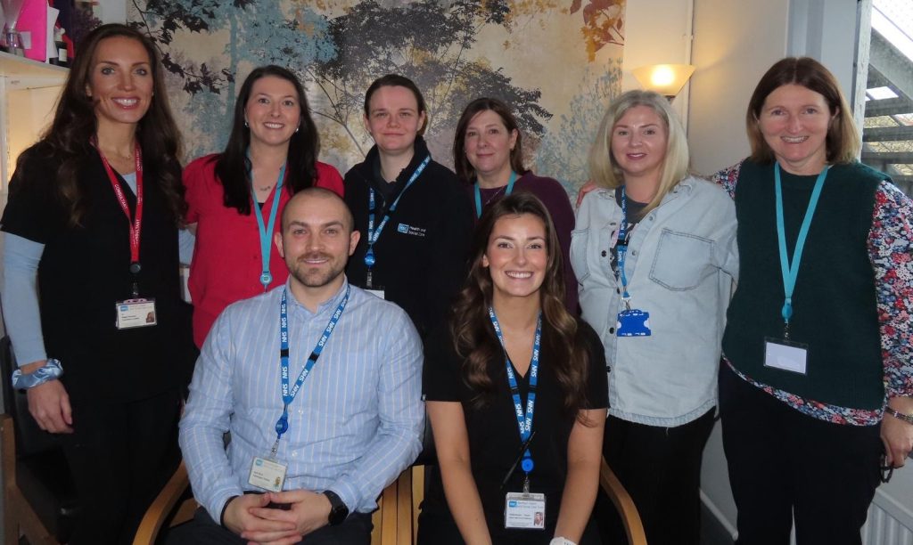 Six people standing and two sitting who work for CAMHS in Northern Trust