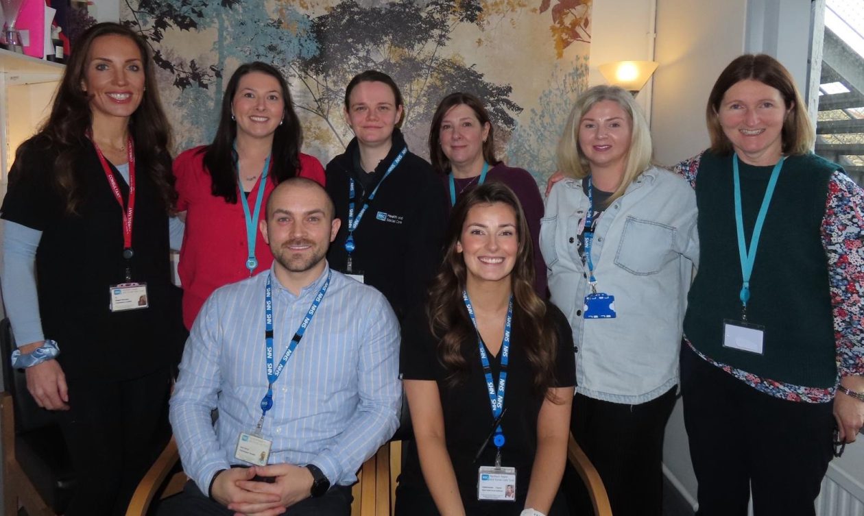 Six people standing and two sitting who work for CAMHS in Northern Trust.