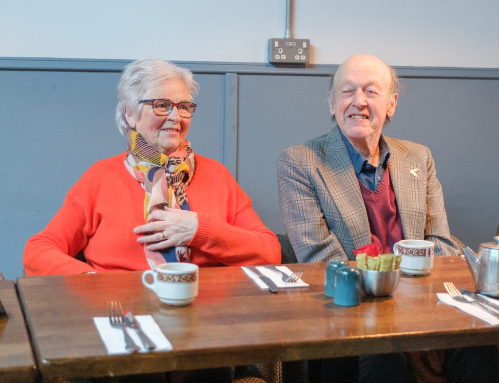 A man and a woman sitting together at a table.