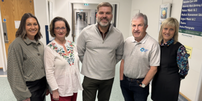 Five people standing together in a hospital corridor.