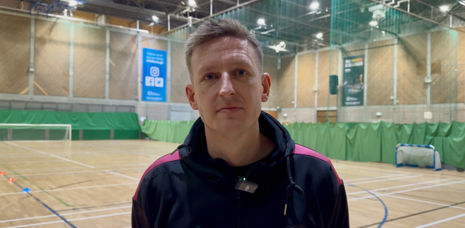 Man standing in indoor football pitch.