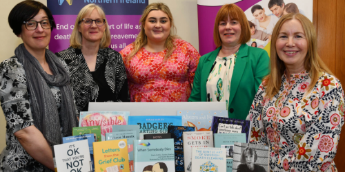 Five women standing behind a display about books about death and bereavement.