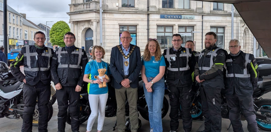 A group of people including fostering staff, the Mayor of Mid and East Antrim Borough CounciI and bikers who took part in the Foster 400 bike tour standing together in the band stand in Ballymena.