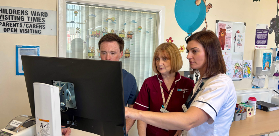 Doctor, Nurse and Dietitian standing in front of computer in Children's Ward