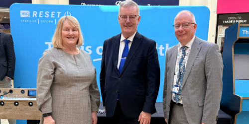 The Chief Executive of the Northern Trust stands with the Health Minister Mike Nesbitt and another man, with a This is our Health backdrop.