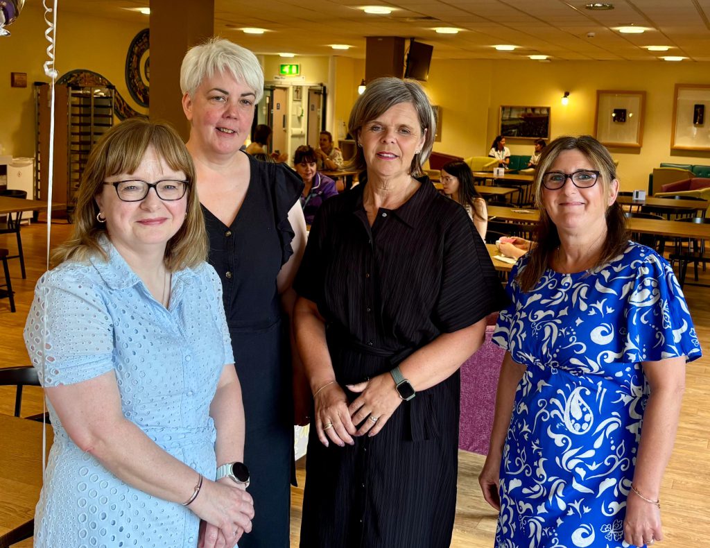 Four women standing together.