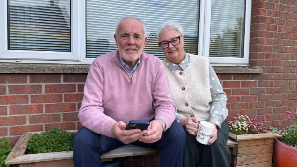 Man and woman sitting on garden seat.