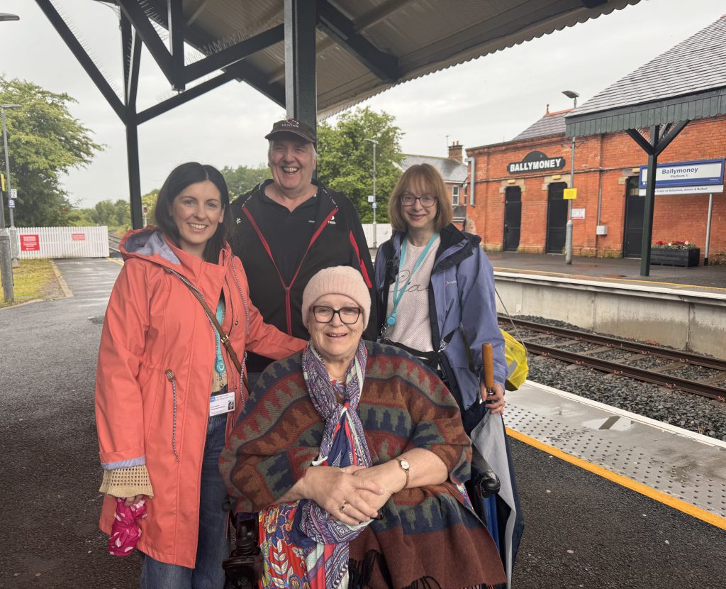 A group of people standing on the platform at Ballymoney station.