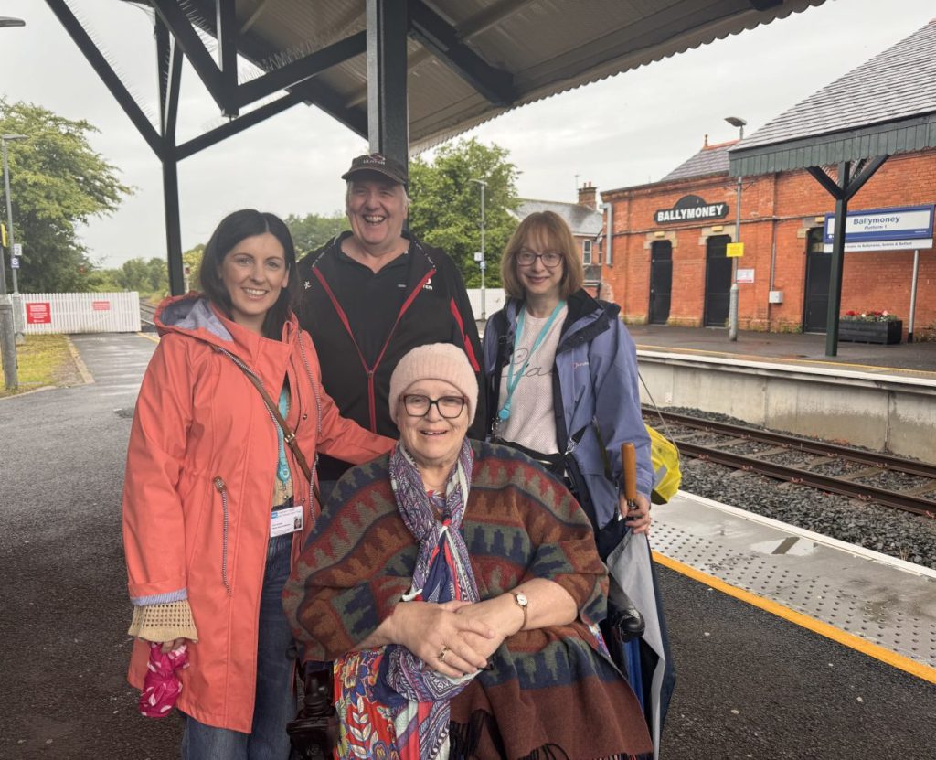 A group of people standing on the platform at Ballymoney station.