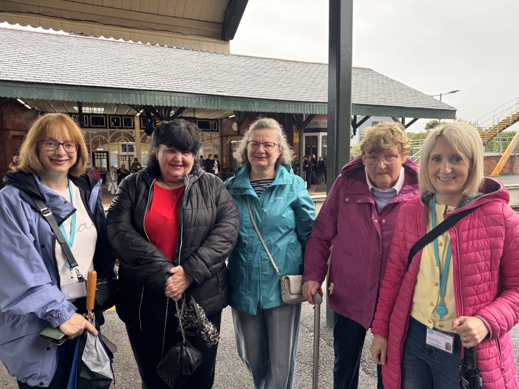 A group of people standing on the platform at Ballymoney station.