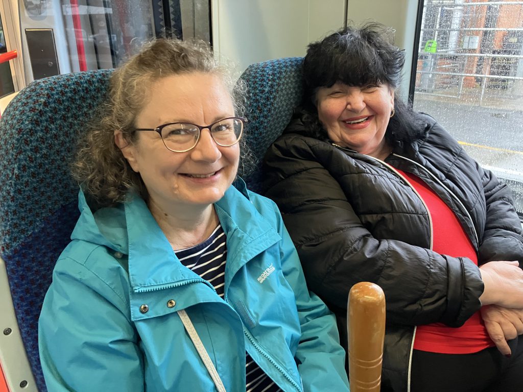 Four women sitting beside each other on a train.