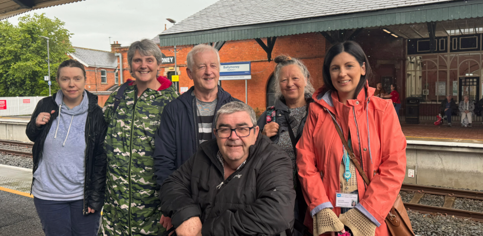 A group of people standing on the platform at Ballymoney station.
