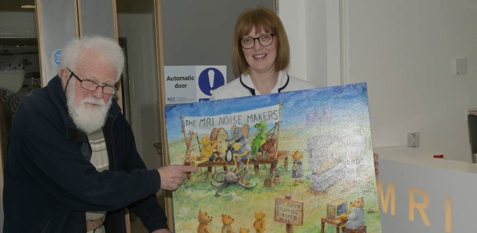 Artist Brian Willis stands beside radiographer Lesley Thompson, who is holding the MRI Noisemakers painting.