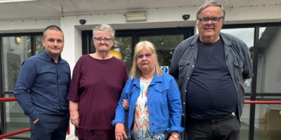 Four people standing outside a building.